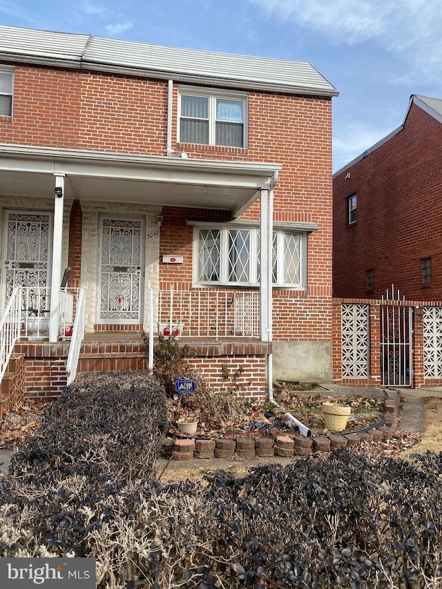 view of front facade with covered porch and brick siding