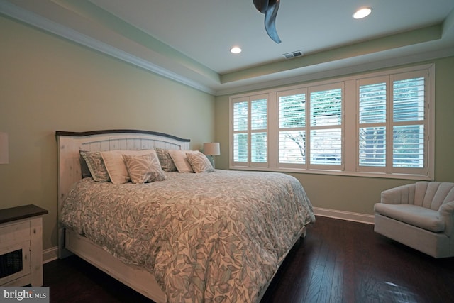 bedroom featuring recessed lighting, visible vents, baseboards, a tray ceiling, and dark wood finished floors