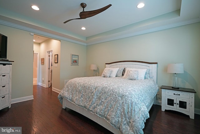 bedroom featuring a tray ceiling, dark wood finished floors, and recessed lighting