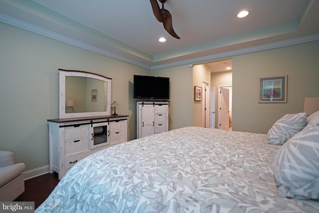 bedroom featuring ornamental molding, a tray ceiling, dark wood-style flooring, and recessed lighting