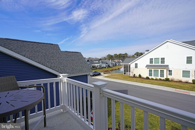 balcony featuring a residential view and a water view