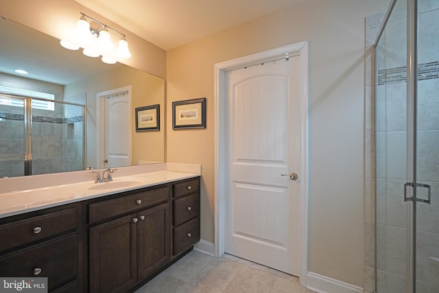 full bathroom featuring a stall shower, tile patterned flooring, baseboards, and vanity