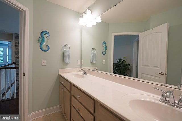 bathroom with tile patterned flooring, a sink, baseboards, and double vanity