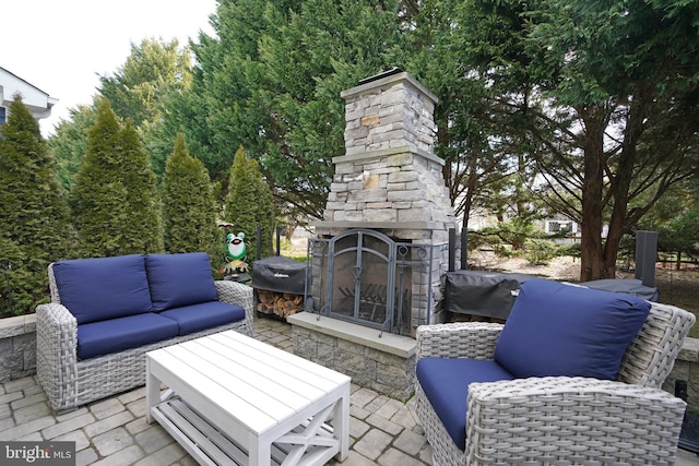 view of patio / terrace with an outdoor stone fireplace and grilling area