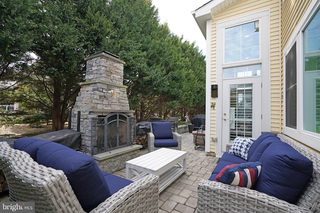 view of patio with an outdoor living space with a fireplace