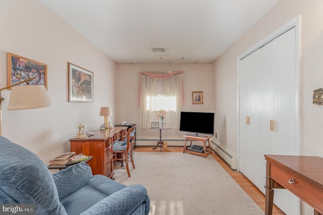 living room with light wood-style flooring, baseboard heating, and visible vents