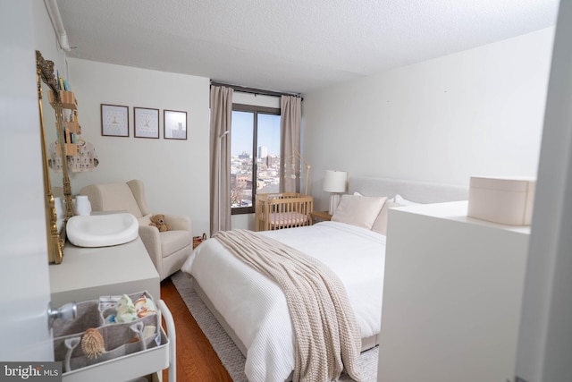 bedroom with a textured ceiling and wood finished floors