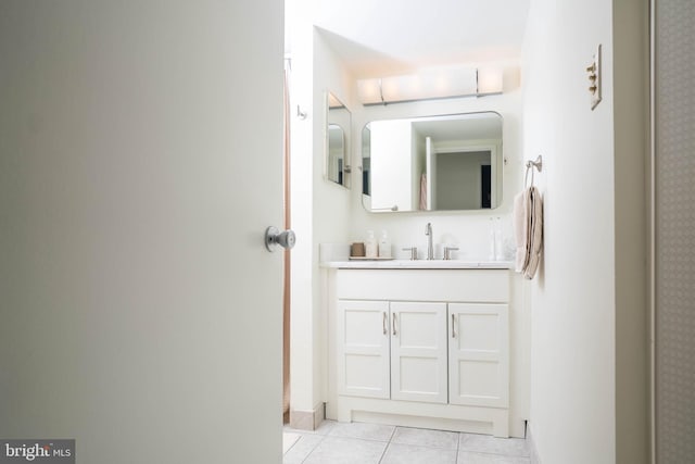 bathroom featuring vanity, baseboards, and tile patterned floors