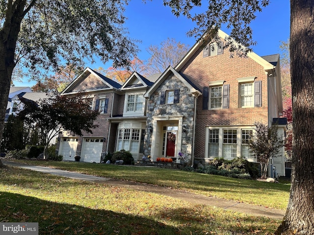 traditional-style house featuring a front yard, an attached garage, brick siding, and stone siding