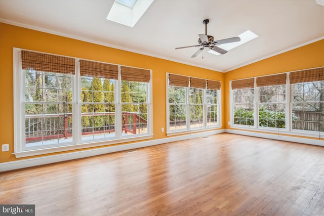 unfurnished sunroom featuring lofted ceiling with skylight, visible vents, and a ceiling fan