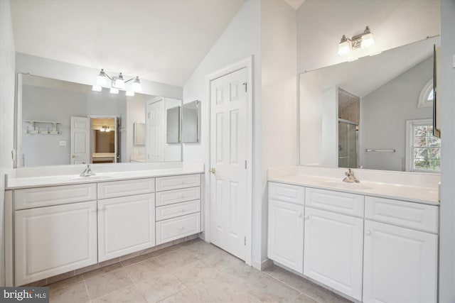 bathroom featuring vaulted ceiling, two vanities, a sink, and a shower stall