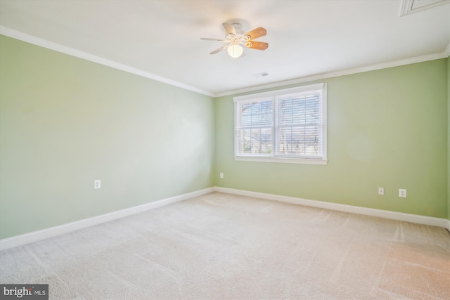 carpeted spare room featuring visible vents, crown molding, and baseboards