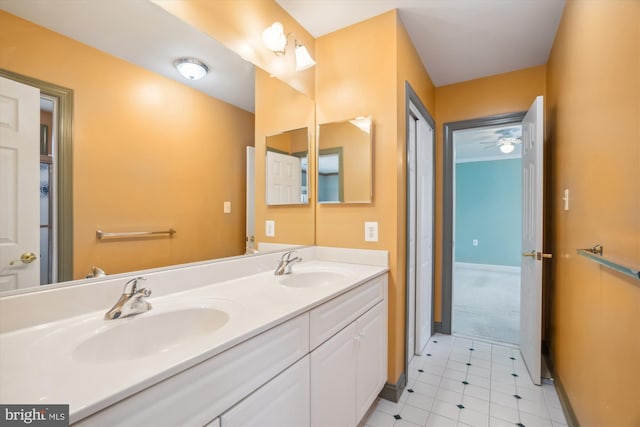 bathroom featuring double vanity, baseboards, and a sink