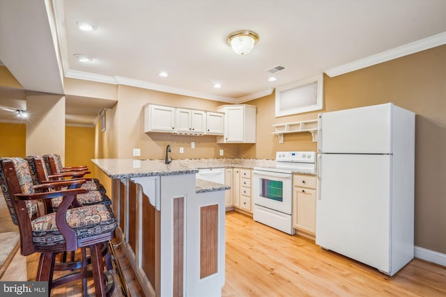 kitchen featuring visible vents, light wood-style floors, ornamental molding, white appliances, and a peninsula