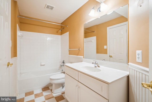 full bath featuring toilet, vanity, visible vents, shower / washtub combination, and wainscoting