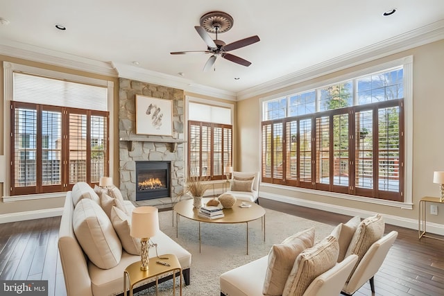 living room with baseboards, dark wood-type flooring, a fireplace, and crown molding