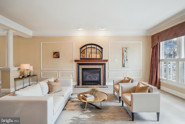 living room with a tile fireplace, baseboards, a decorative wall, and ornate columns