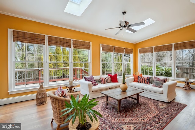 sunroom with a ceiling fan and vaulted ceiling with skylight