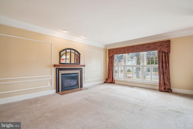 unfurnished living room featuring carpet floors, baseboards, crown molding, and a tile fireplace