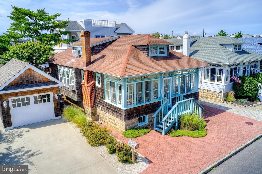 408 N Atlantic Ave, Beach Haven, NJ 08008 - shingle-style home with a shingled roof, decorative driveway, an outdoor structure, and a chimney
