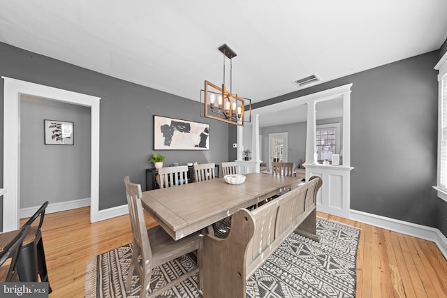 dining area with baseboards, decorative columns, visible vents, and light wood-style floors