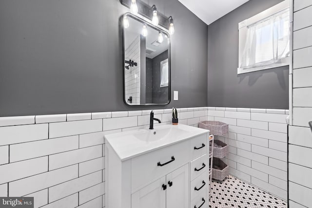 bathroom with wainscoting, tile walls, and vanity