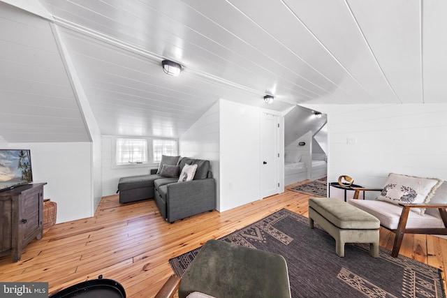 living area with vaulted ceiling and light wood-style flooring