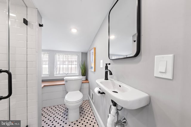 bathroom featuring a shower with shower door, visible vents, and toilet