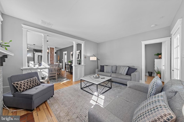 living room with a wealth of natural light, wood finished floors, and visible vents