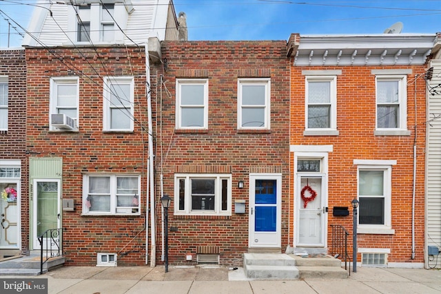 view of property featuring cooling unit, brick siding, and entry steps