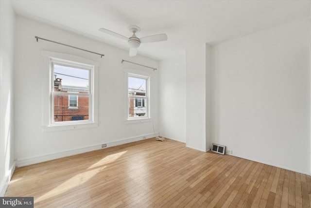 spare room with light wood-style floors, visible vents, and ceiling fan