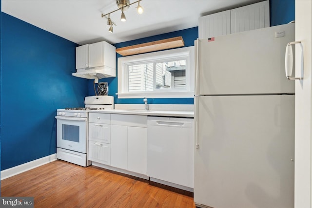 kitchen with light wood-style flooring, white appliances, a sink, white cabinets, and light countertops