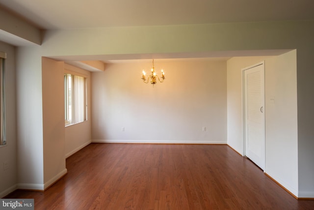 interior space featuring baseboards, wood finished floors, and a chandelier