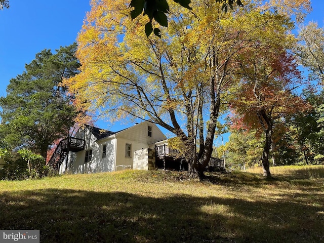 view of front of property featuring a wooden deck, stairway, and a front yard