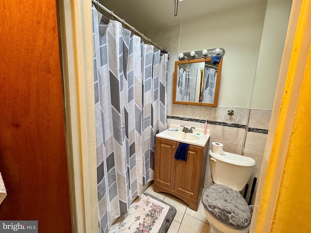 bathroom with tile patterned flooring, tile walls, vanity, and toilet