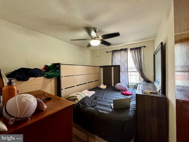 bedroom with a ceiling fan and a textured ceiling