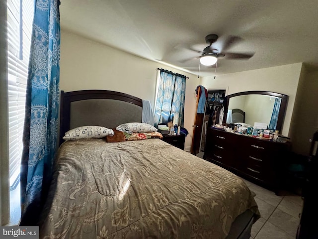 bedroom featuring ceiling fan, multiple windows, and tile patterned flooring