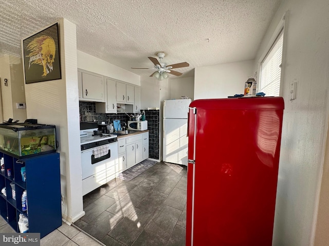 kitchen with ceiling fan, white appliances, a textured ceiling, and decorative backsplash