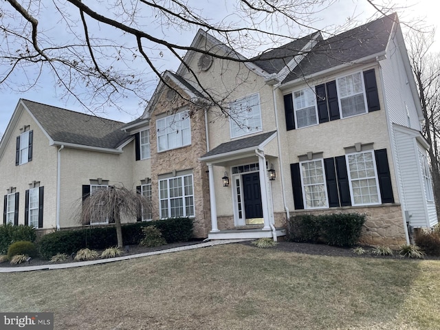 view of front of home with stone siding and a front yard