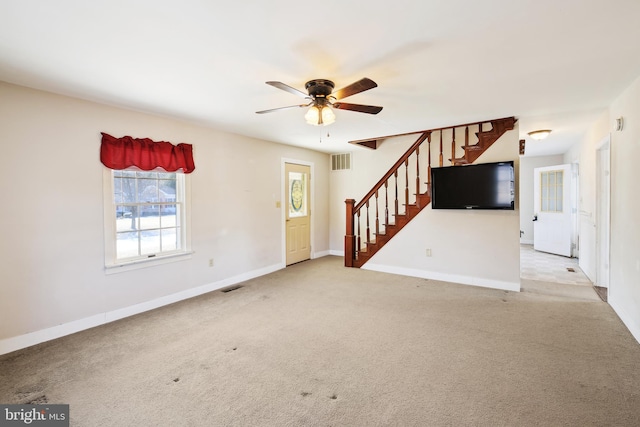 empty room with light colored carpet, visible vents, baseboards, and stairs