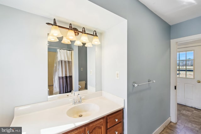 full bathroom featuring curtained shower, vanity, toilet, and baseboards