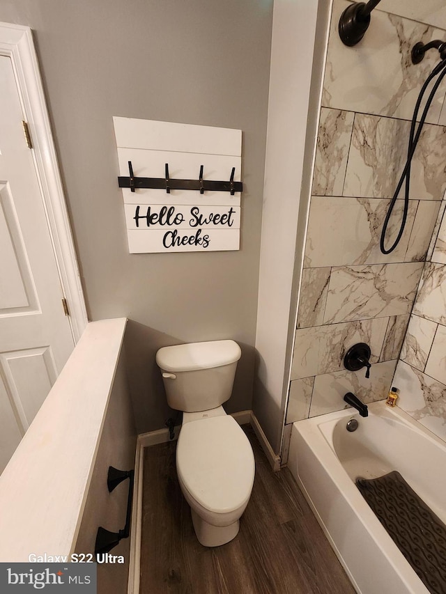 full bath featuring shower / bathing tub combination, toilet, wood finished floors, and baseboards