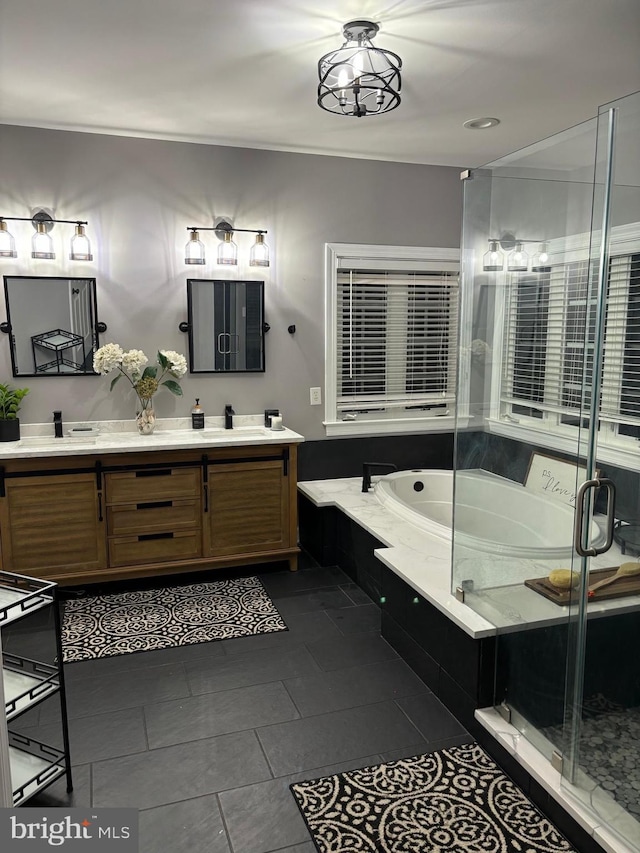 bathroom featuring double vanity, a stall shower, a sink, a garden tub, and tile patterned floors