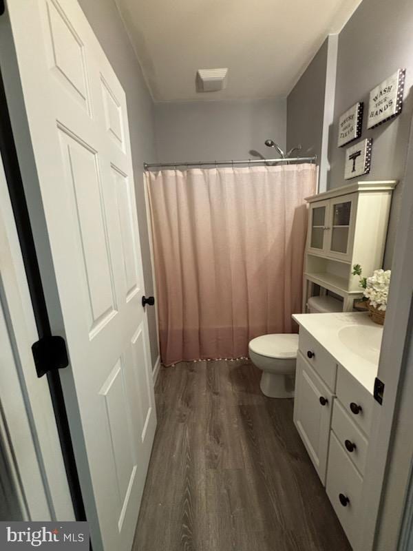 full bathroom with toilet, vanity, a shower with shower curtain, and wood finished floors