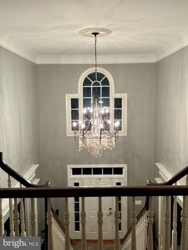 stairway featuring an inviting chandelier and ornamental molding