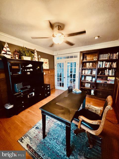 office area with a ceiling fan, wood finished floors, french doors, and ornamental molding