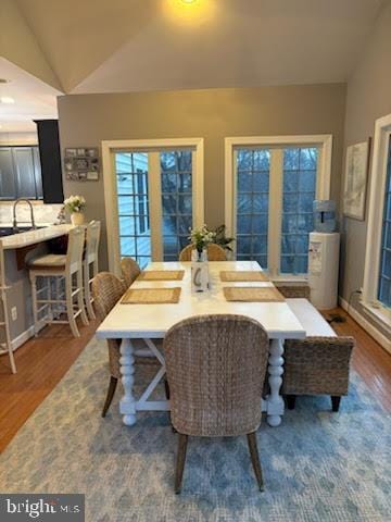 dining room featuring wood finished floors and vaulted ceiling