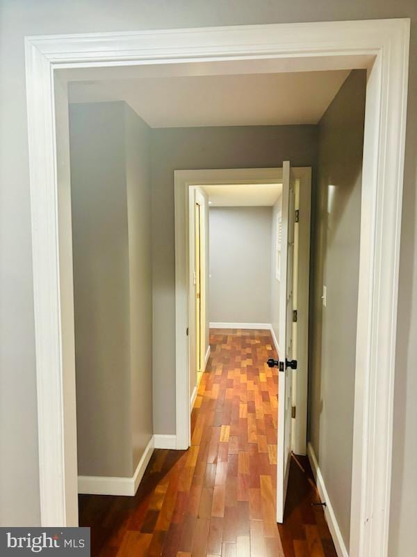 hallway with baseboards and wood finished floors