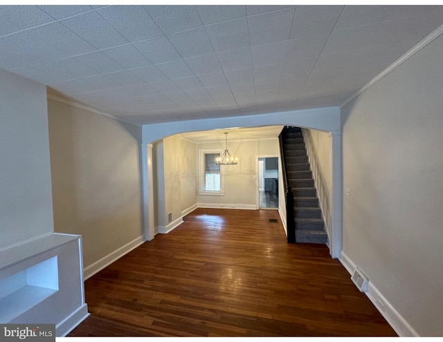 interior space featuring arched walkways, dark wood-style flooring, stairway, and baseboards