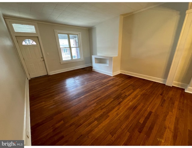 entrance foyer featuring dark wood-style floors, baseboards, and ornamental molding